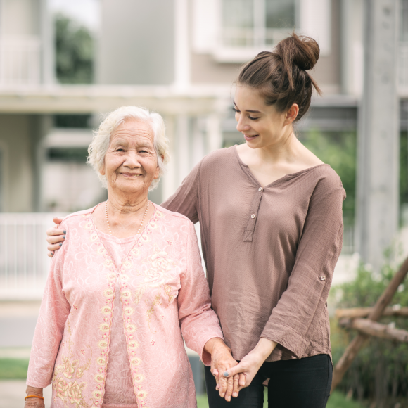 Woman walking and embracing elderly woman