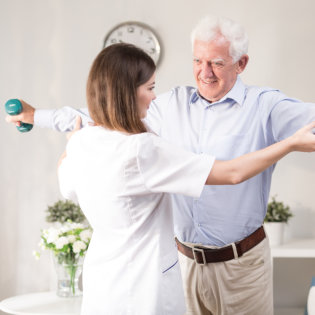 aide assisting an elderly man in exercising