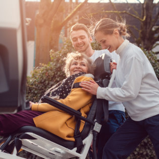caregivers assisted an elderly woman in getting on the car