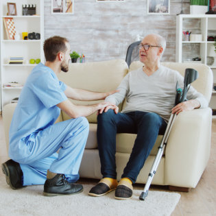 aide talking to an elderly man