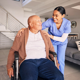 aide and elderly man smiling at each other