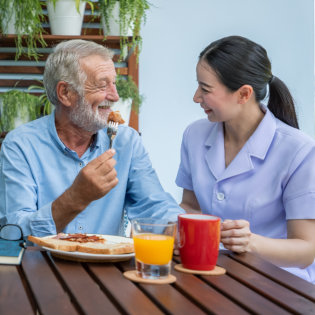 aide and elderly man smiling