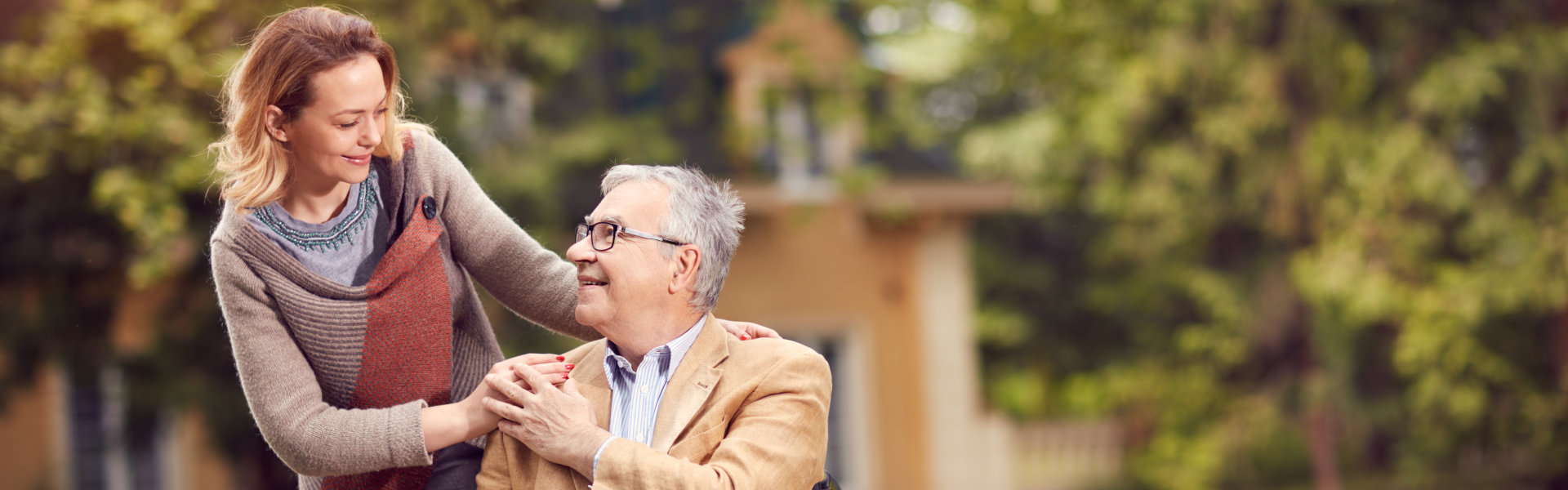 elderly men in wheelchair with happy caregiver daughter