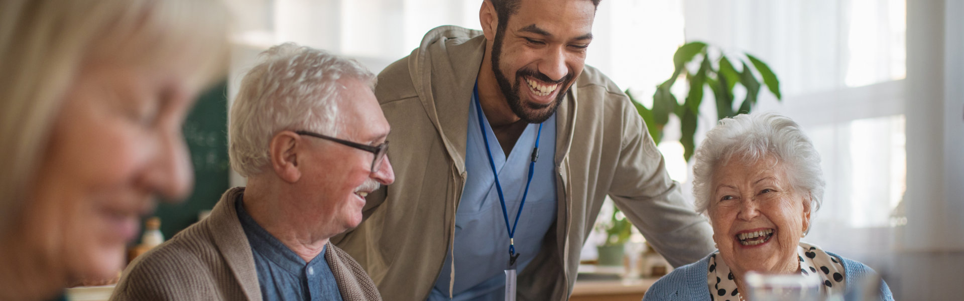 Group of cheerful elderly enjoying breakfast in nursing home care center