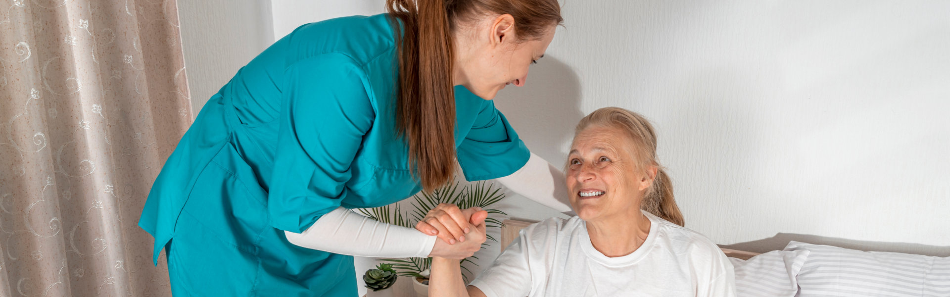 aide assisting ang elderly woman in getting up